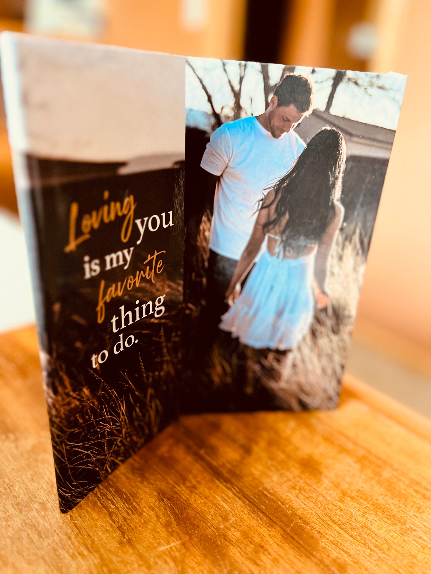 The Fisherman Series hardcover dust jacket quote next to the case laminate cover image of a man in a white top and woman in a white dress. The quote reads loving you is my favorite thing to do.